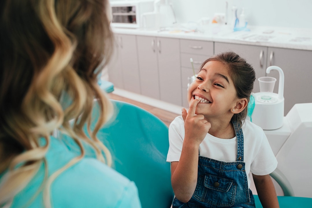 Petite fille montrant ses dents à son dentiste